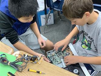 Students deconstructing a computer. 